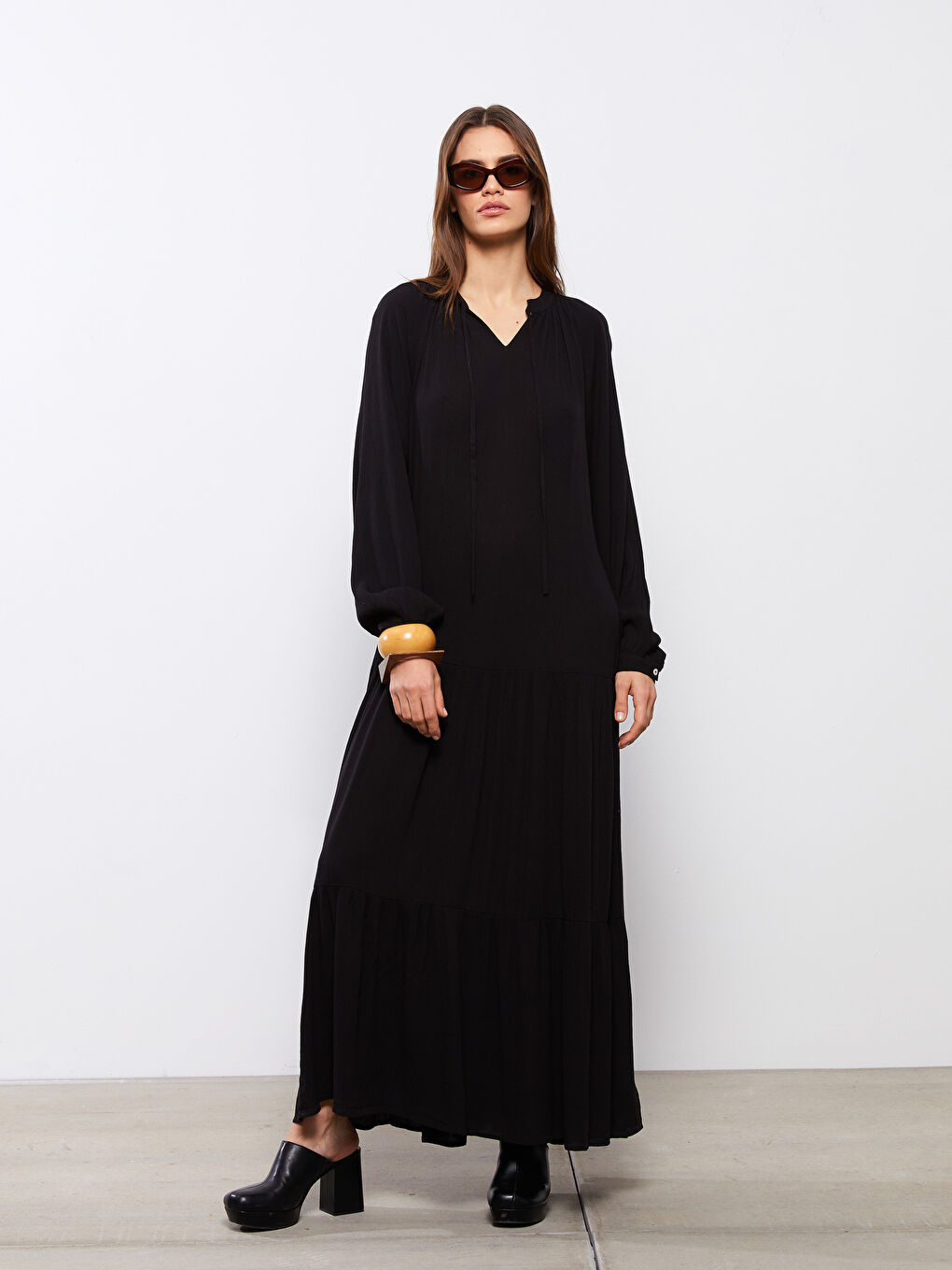 فستان نسائي مجعد بقصة ضيقة من أعلى وواسعة من أسفل وكم طويل بقصة مستقيمة وقُبة بربطة عنق