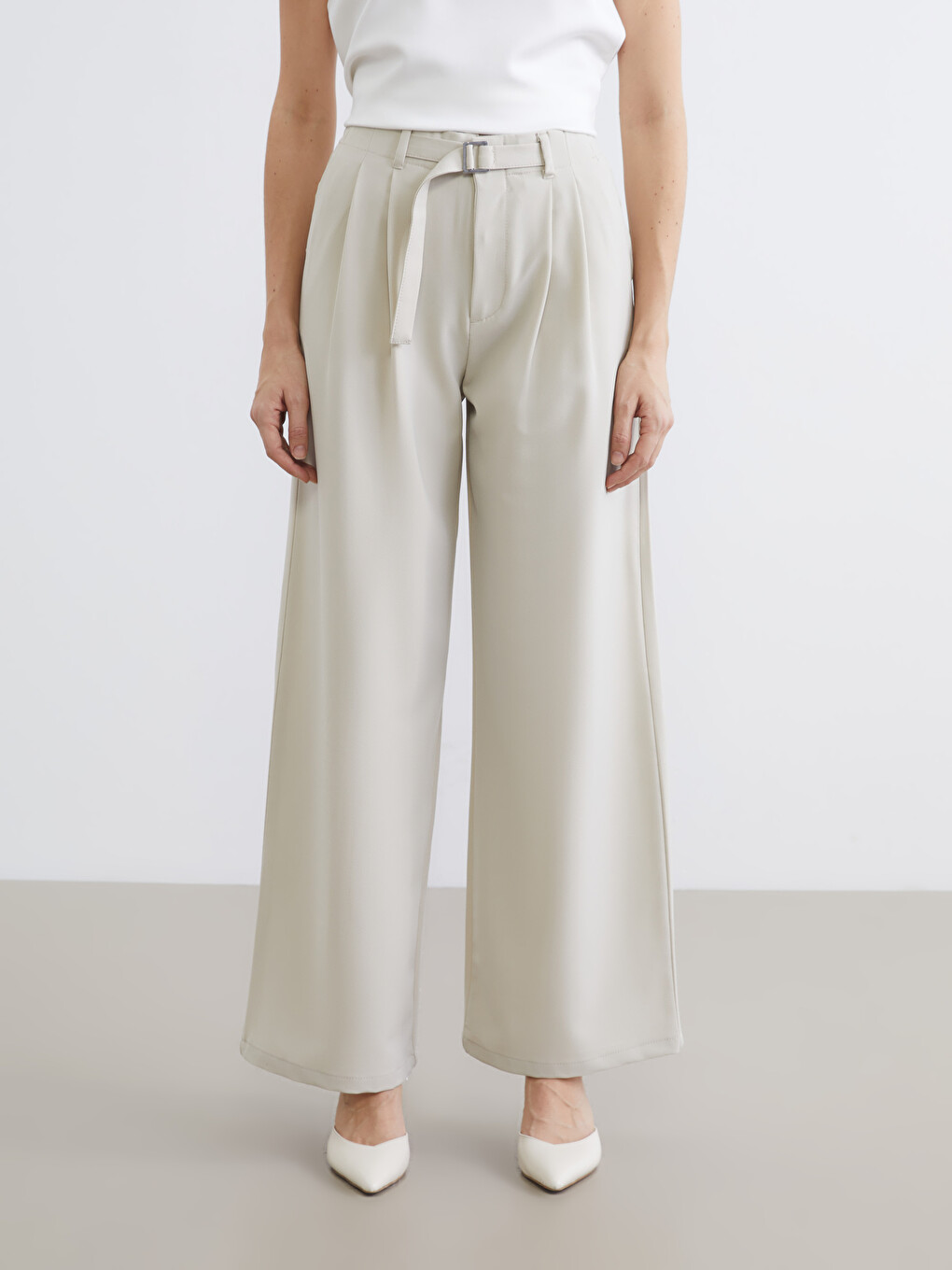Belted, loose-fit, pleated trousers for women.-1