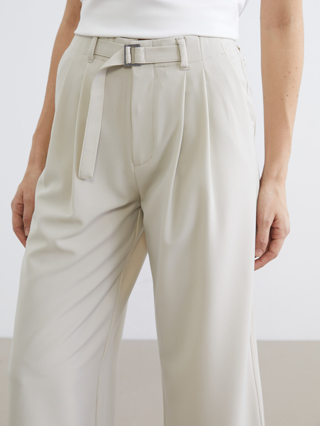 Belted, loose-fit, pleated trousers for women.-2