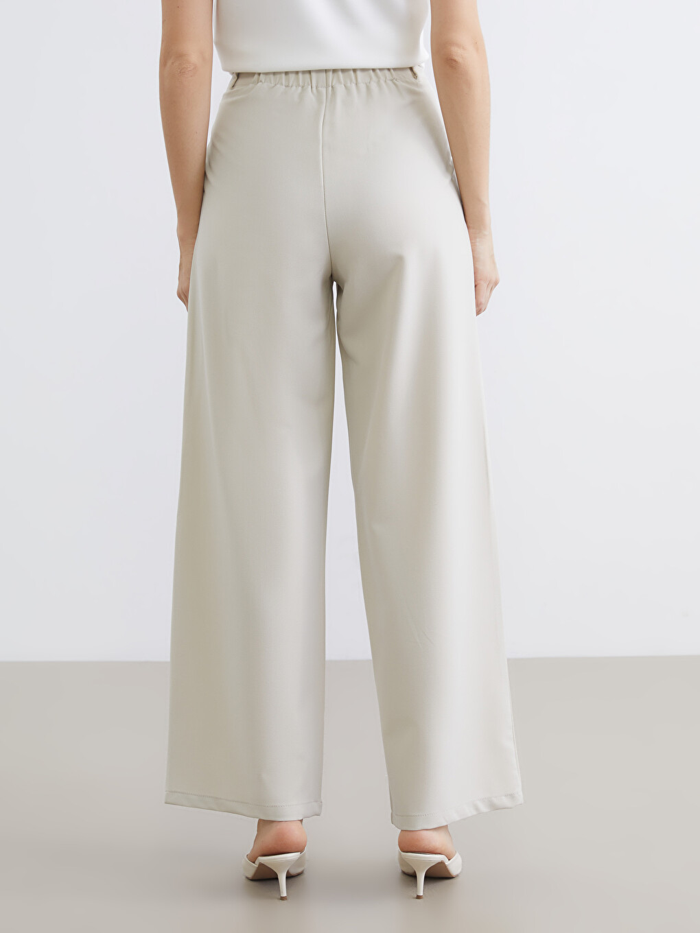 Belted, loose-fit, pleated trousers for women.-3