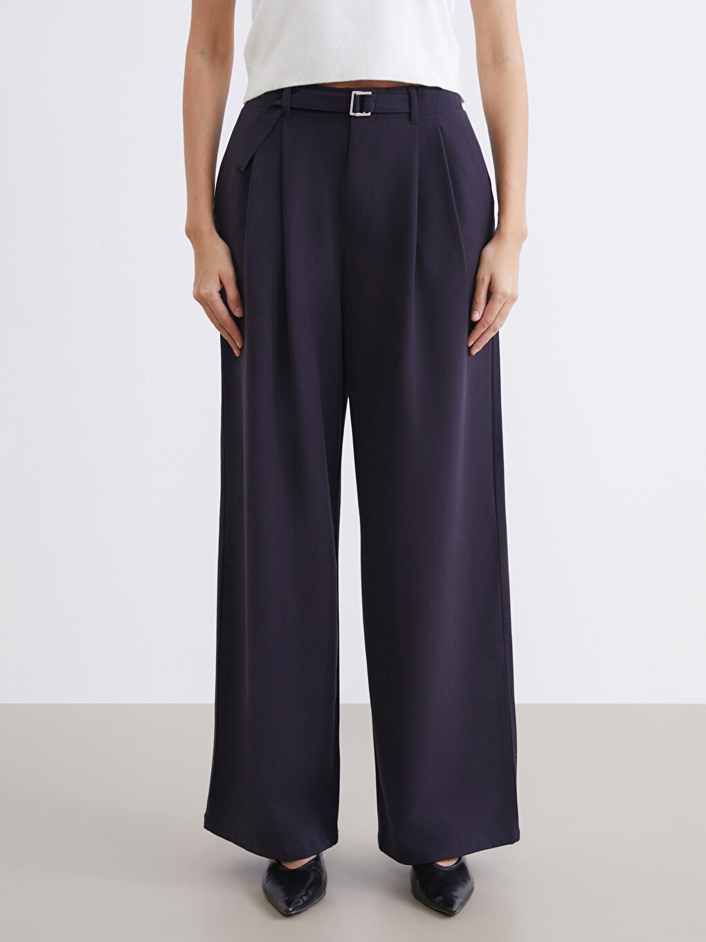 Belted, loose-fit, pleated trousers for women.-1