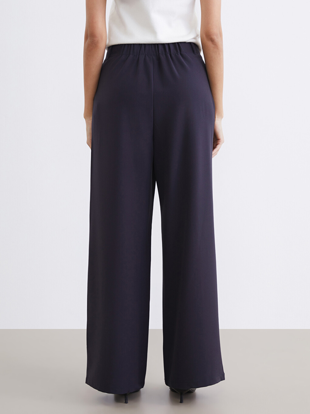 Belted, loose-fit, pleated trousers for women.-3