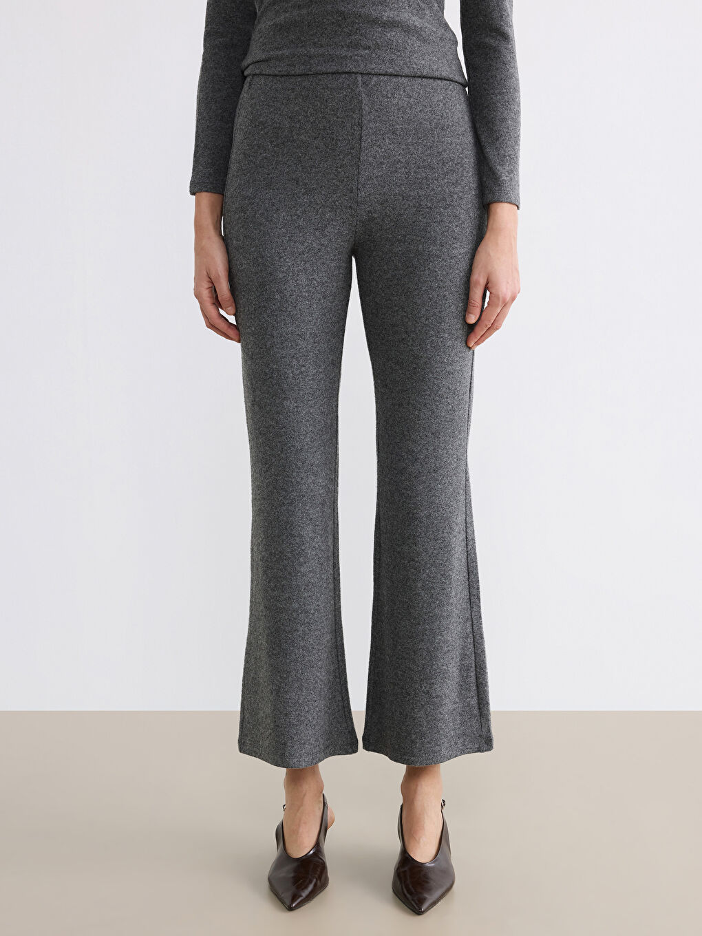 Непринуждённая элегантность сочетается с повседневным комфортом в наших брюках с эластичным поясом и расклешёнными штанинами.-1
