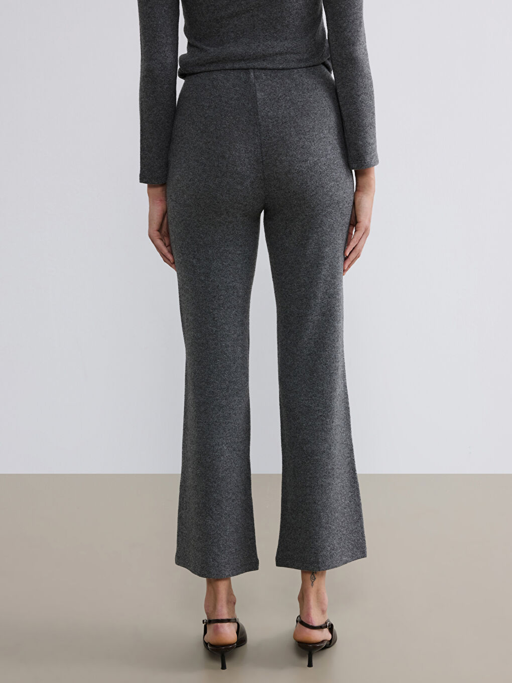 Непринуждённая элегантность сочетается с повседневным комфортом в наших брюках с эластичным поясом и расклешёнными штанинами.-3