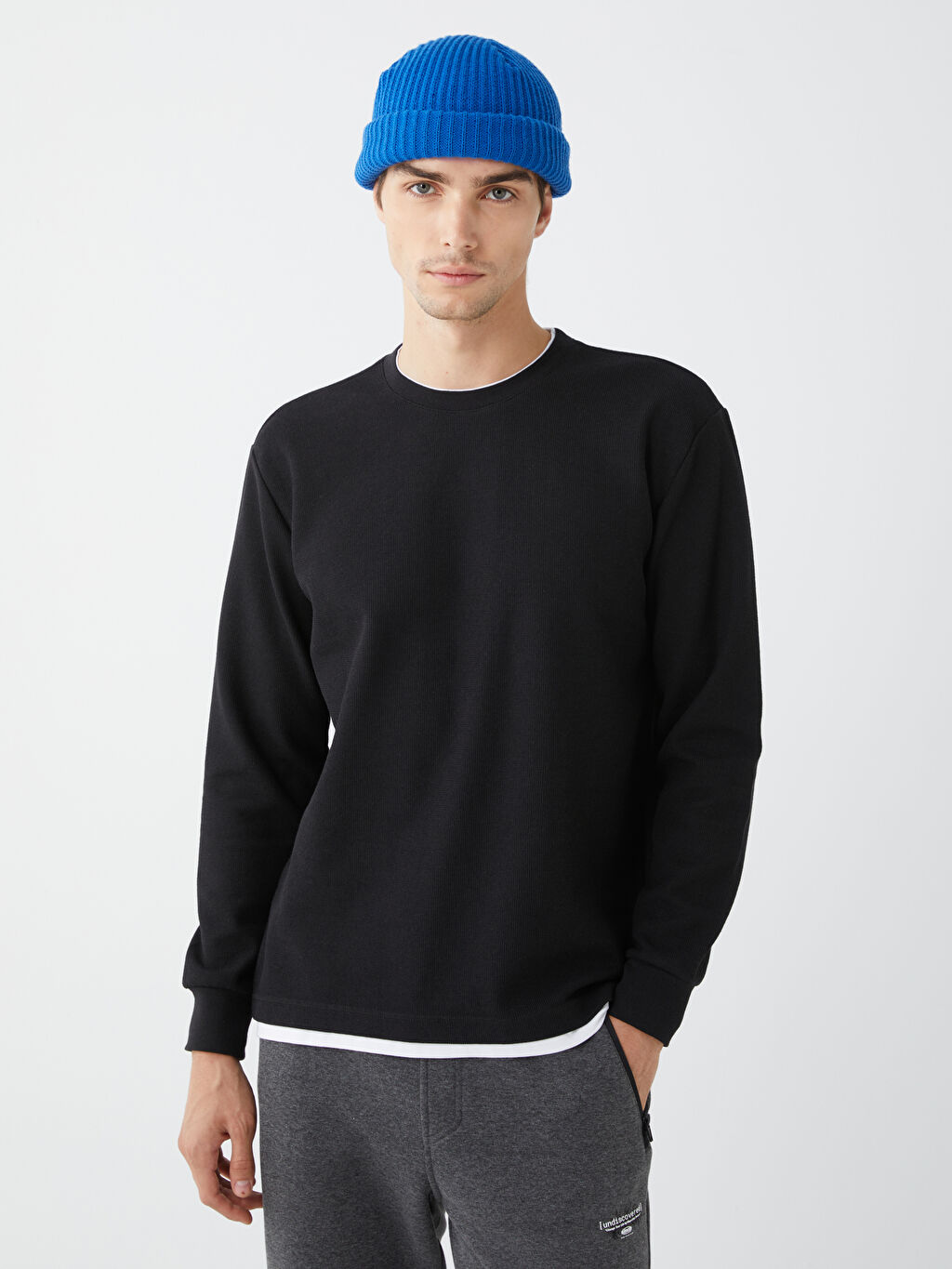 Man in black and white crew neck t-shirt wearing gray cap photo